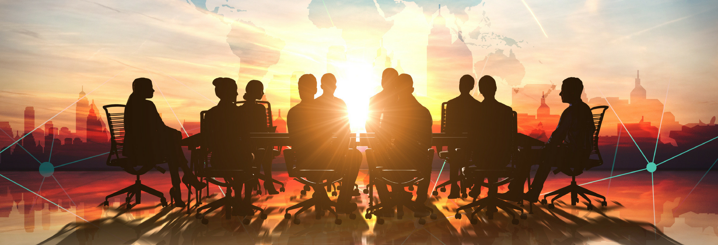 A group of people sitting at a conference table with the sun shining through the window.
